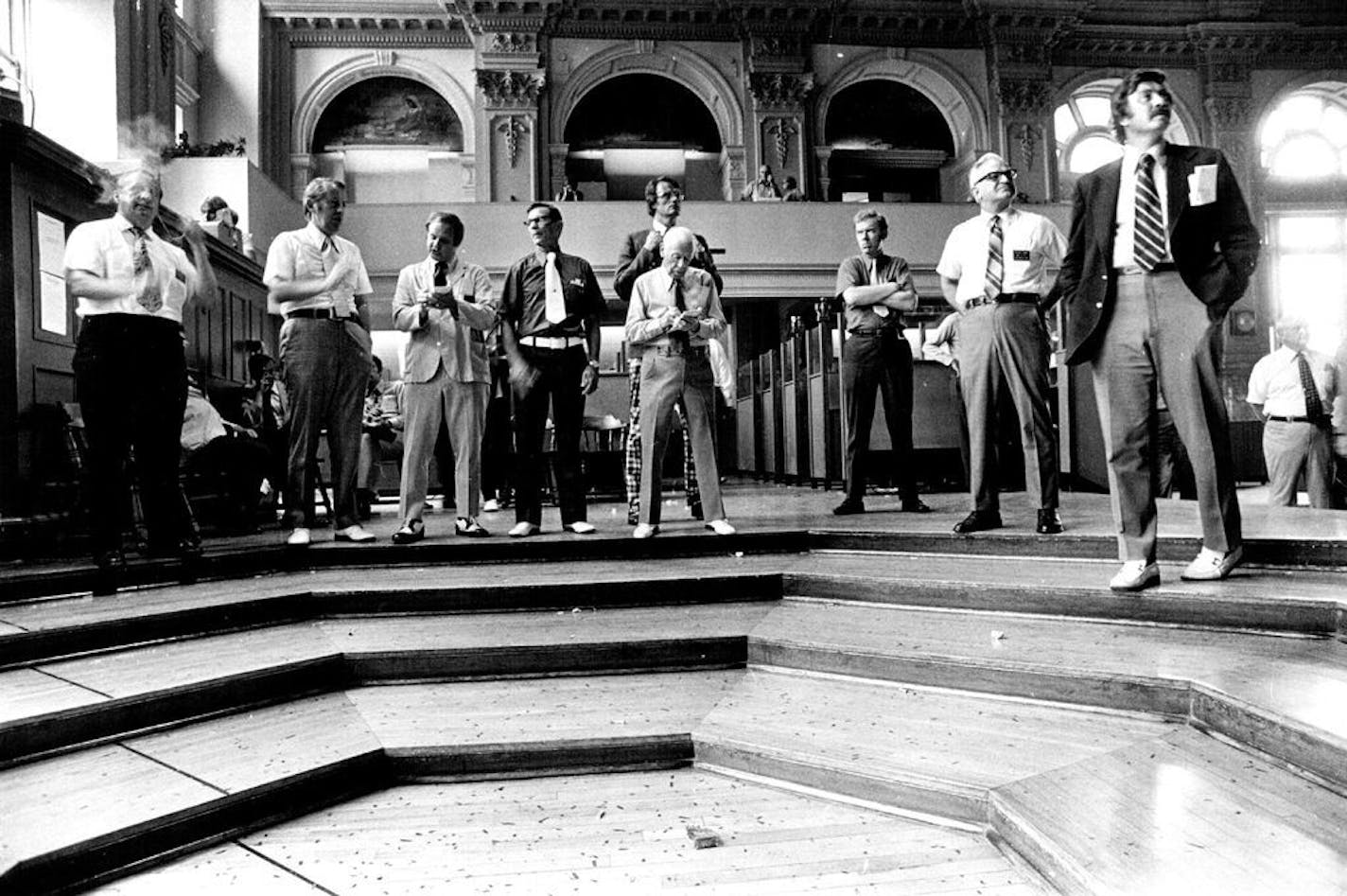 For much of the day, the grain pit looked like this: a small group of traders, standing around and watching the changing wheat prices being chalked on the big board, in September 1973.