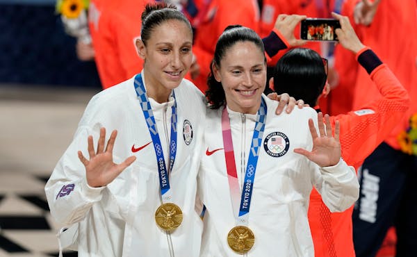 Sue Bird, right, and Diana Taurasi pose with their gold medals during the medal ceremony for women's basketball at the 2020 Summer Olympics