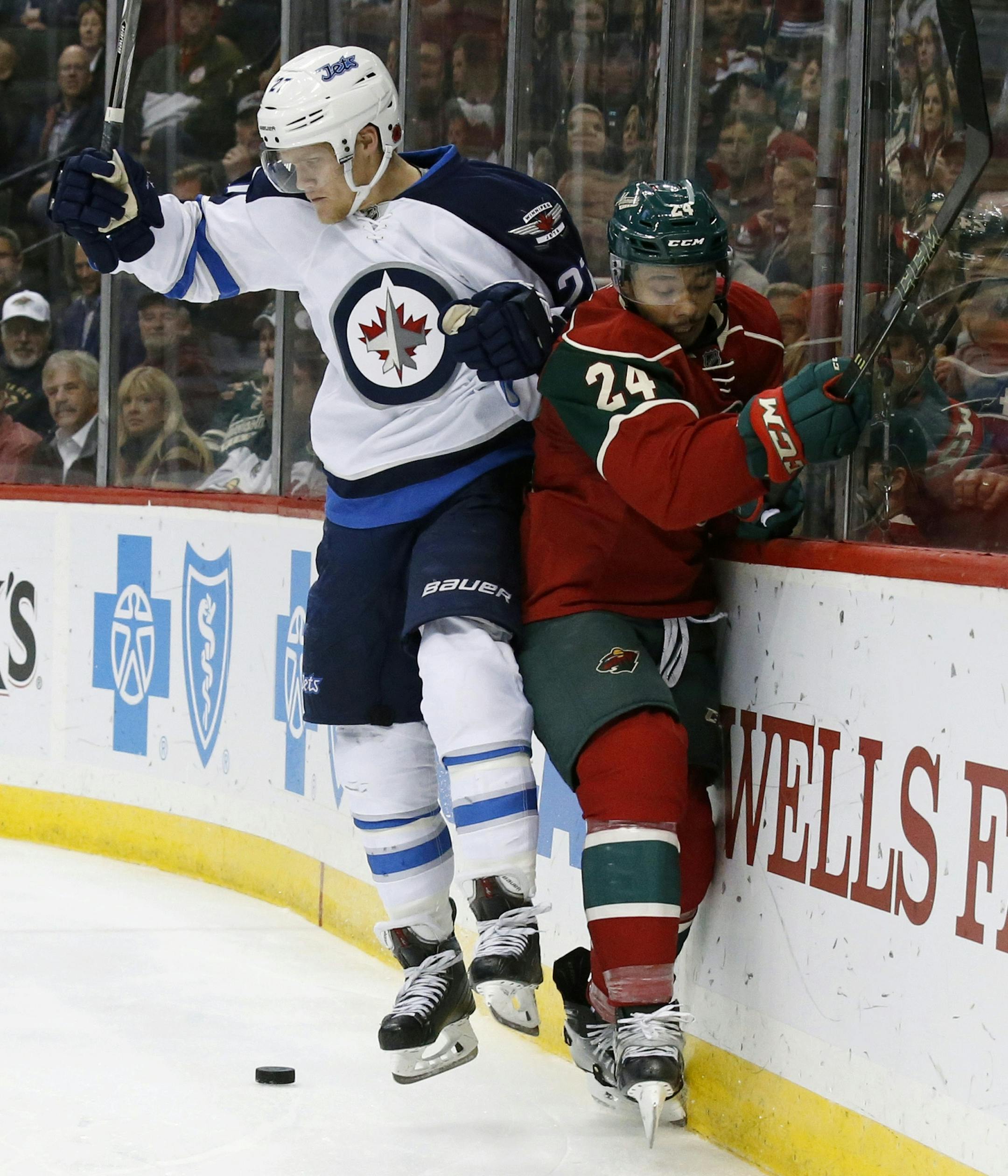 Winnipeg Jets left wing Nikolaj Ehlers, left, of Denmark, checks Minnesota Wild defenseman Matt Dumba (24) into the boards during the second period of an NHL hockey game in St. Paul, Minn., Tuesday, Nov. 10, 2015. (AP Photo/Ann Heisenfelt)