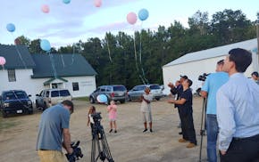 Peace activist KG Wilson, wearing hat, released balloons last week near the spot where four people were found slain. Damone Presley Sr., the father of