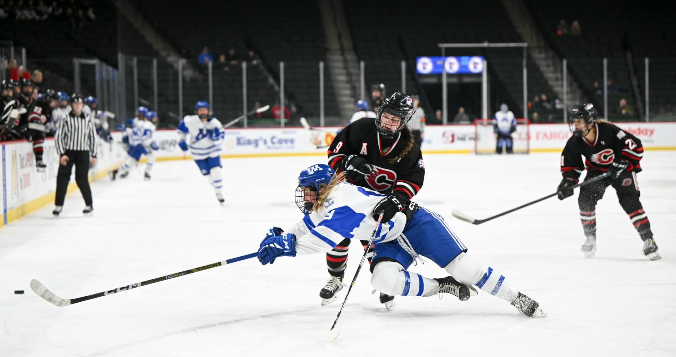 Minnetonka forward Lindzi Avar (13) and Centennial/ Spring Lake Park forward Ella O'Hearn (9) battle for the puck during the first period of a Class 2A girls' hockey state tournament quarterfinal game Thursday, Feb. 23, 2023 in St. Paul, Minn.