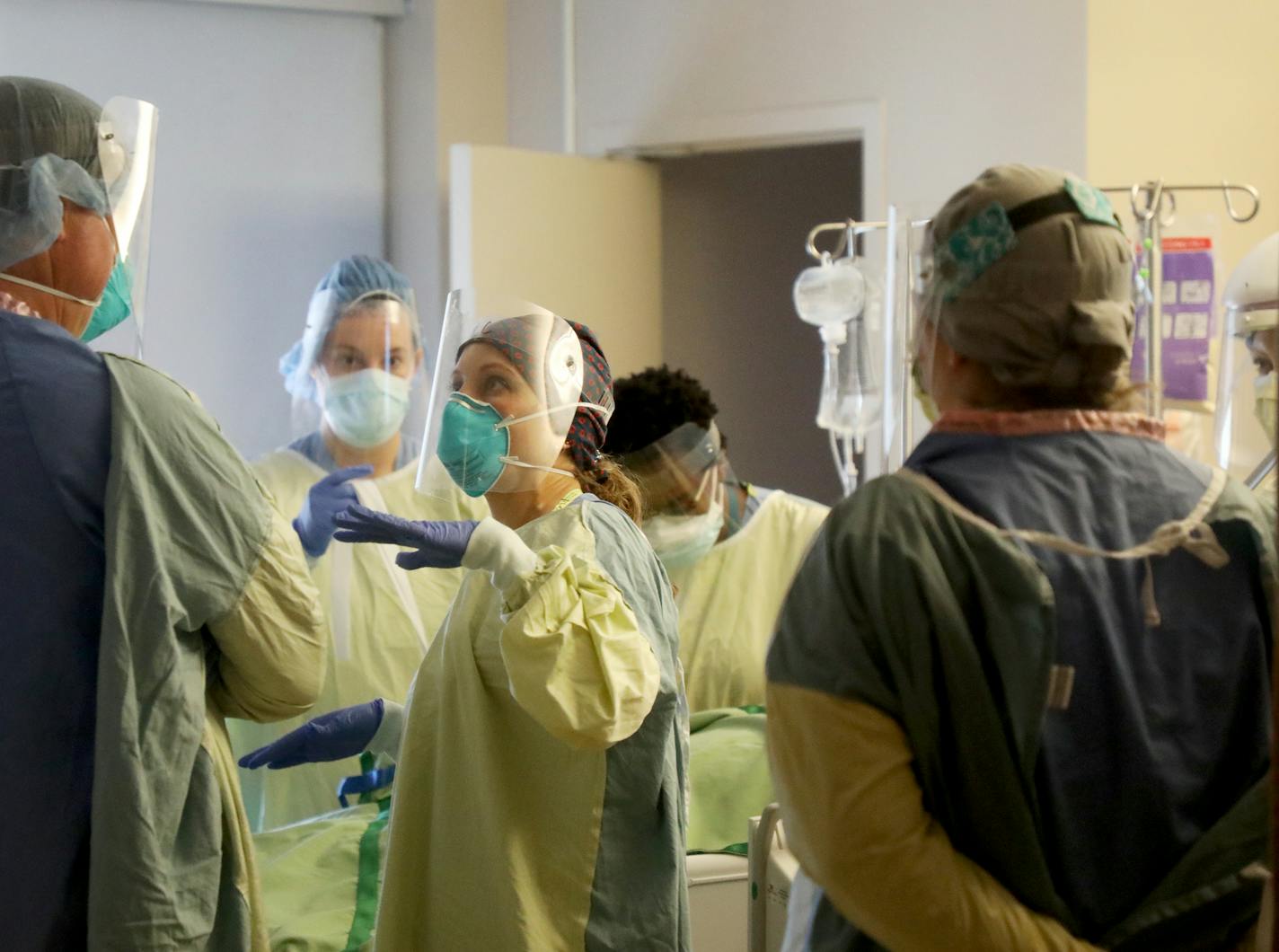 Leah Chapman, an RN, center, confers with a fellow health-care worker after they rotated a COVID-19 patient in the third floor ICU at Bethesda Hospital.