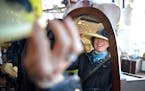 Patricia Farnham tries on hats before selecting the perfect one to take home at Scarborough Fair Boutique's Hats, Horses & High Tea event.
