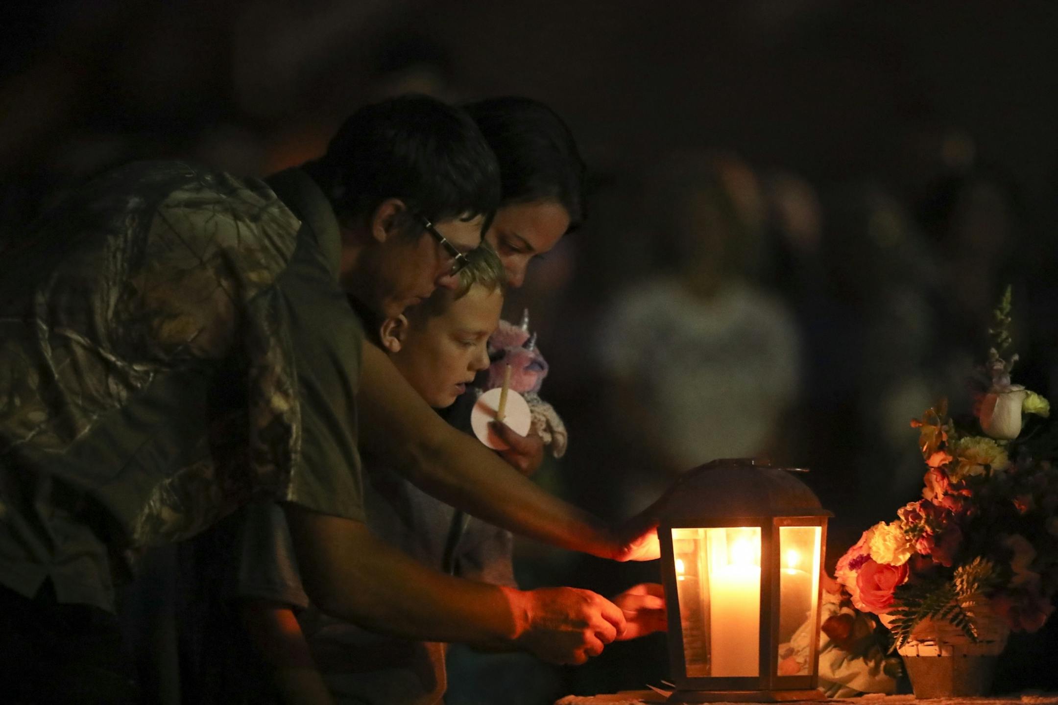 The family of Alayna Ertl, her parents Matt and Kayla and older brother, Carter, lit their candles first during the prayer vigil for Alayna Ertl Tuesday night in the parking lot of St. Anthony Church in Watkins.