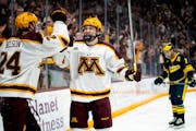 Gophers forward Jimmy Snuggerud, middle, celebrates with captain Jaxon Nelson after a March 1 goal against Michigan.