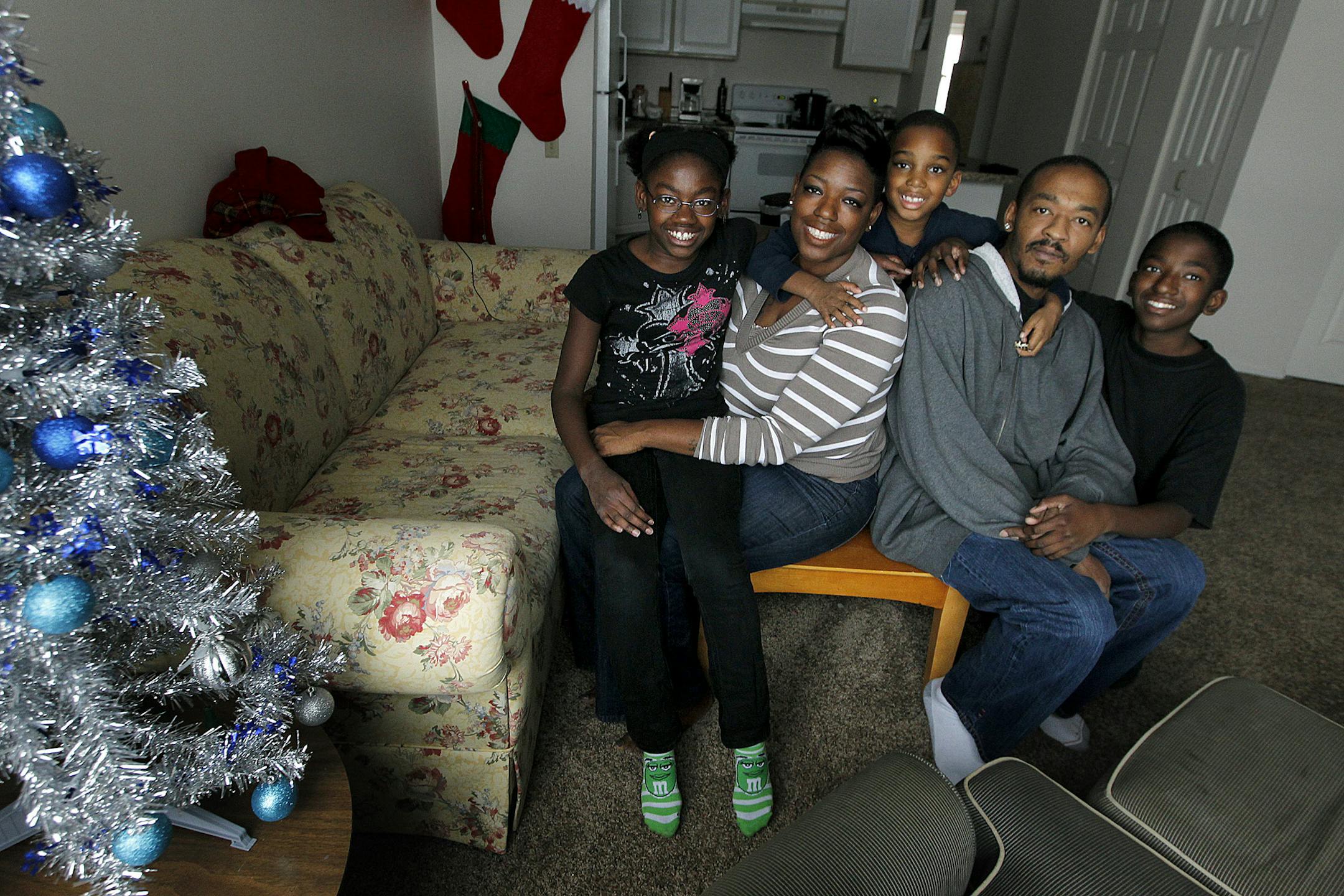 Iraq war veteran Kawayn Johnson with his wife Clarise, and their three children, Sierra, 10, left, Jayden Jones, 6, center, and Kawayn Johnson, 11, right, sat in their new home, Wednesday, December 5, 2013. Johnson took his homeless family to Family Promise in Anoka County hoping to find housing and work. They found a new home but the estranged couple also ended up getting remarried in a ceremony planned and paid for by volunteers of the nonprofit agency. Now the couple and their three kids live