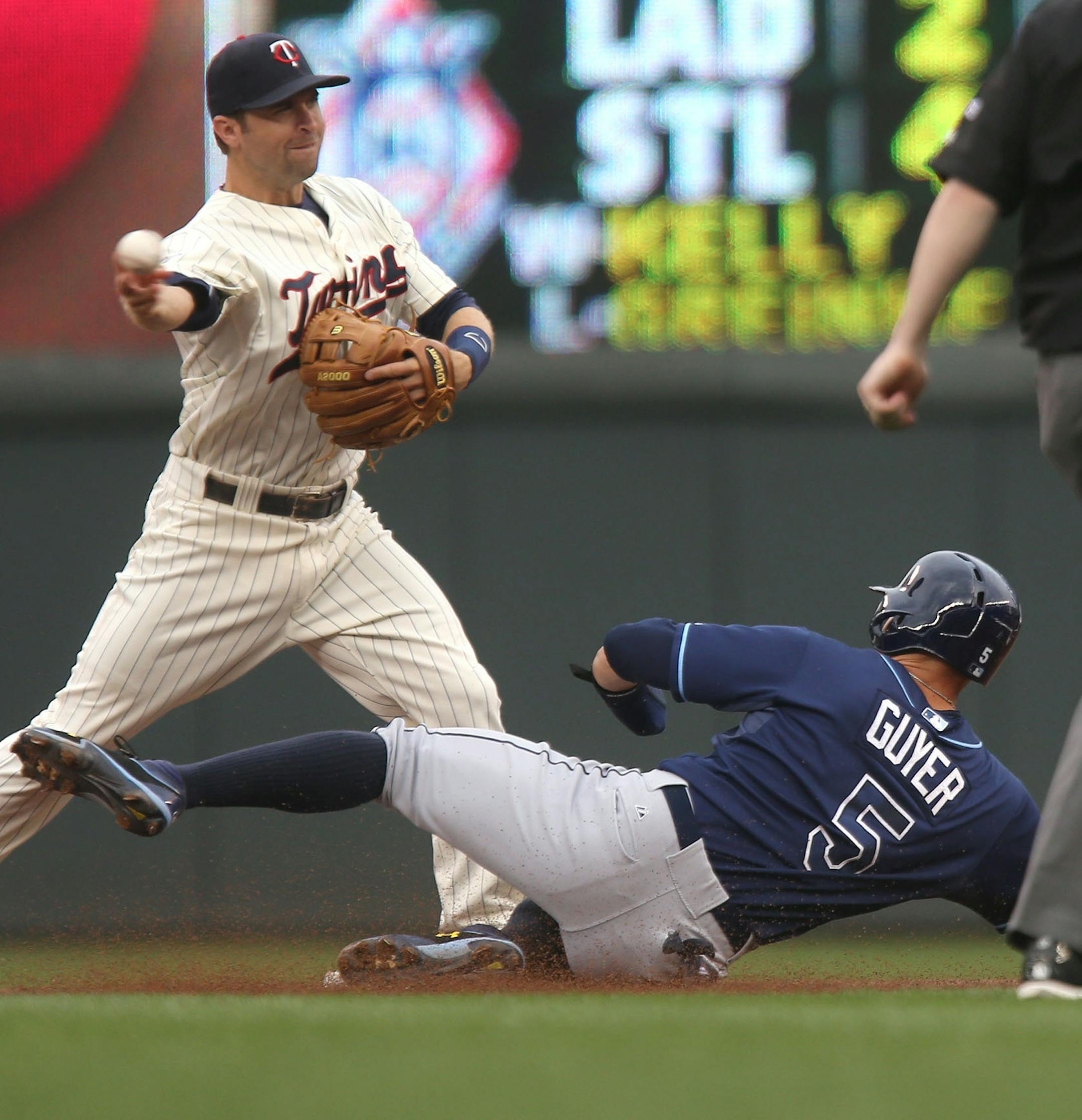 Twins Brian Dozier got out Tampa Bays Brandon Guyer at second and turn the double play at first in the first inning. ] (KYNDELL HARKNESS/STAR TRIBUNE) kyndell.harkness@startribune.com Twins vs Tampa Bay Rays at Target Field in Minneapolis, Min. Saturday, July 19, 2014.