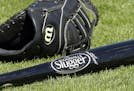 A Wilson baseball glove and a Louisville slugger bat sit on the field prior to a spring training baseball game between the Kansas City Royals and the 