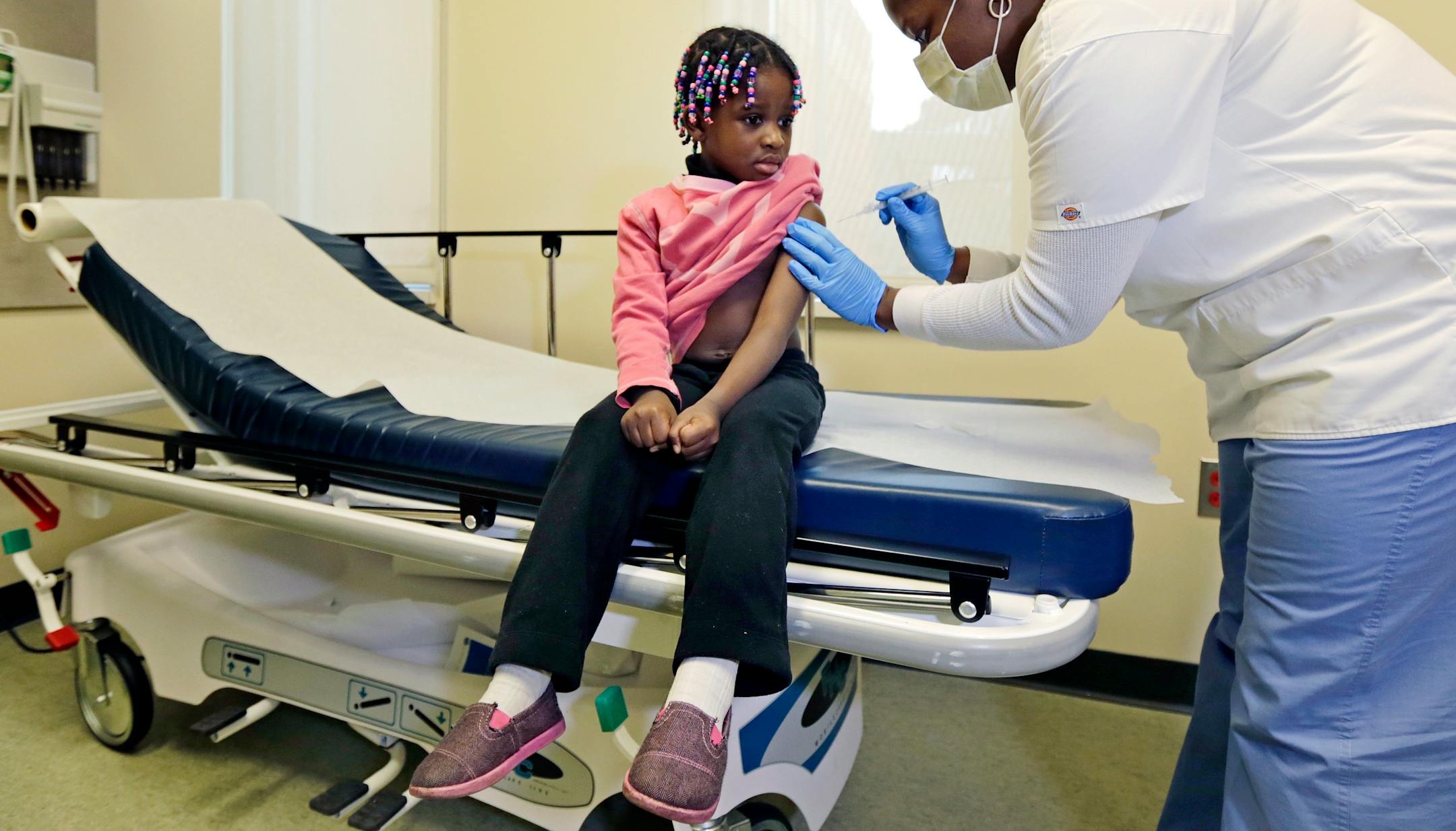 Four-year-old Gabriella Diaz sits as registered nurse Charlene Luxcin administers a flu shot at the Whittier Street Health Center in Boston, Mass., Wednesday.