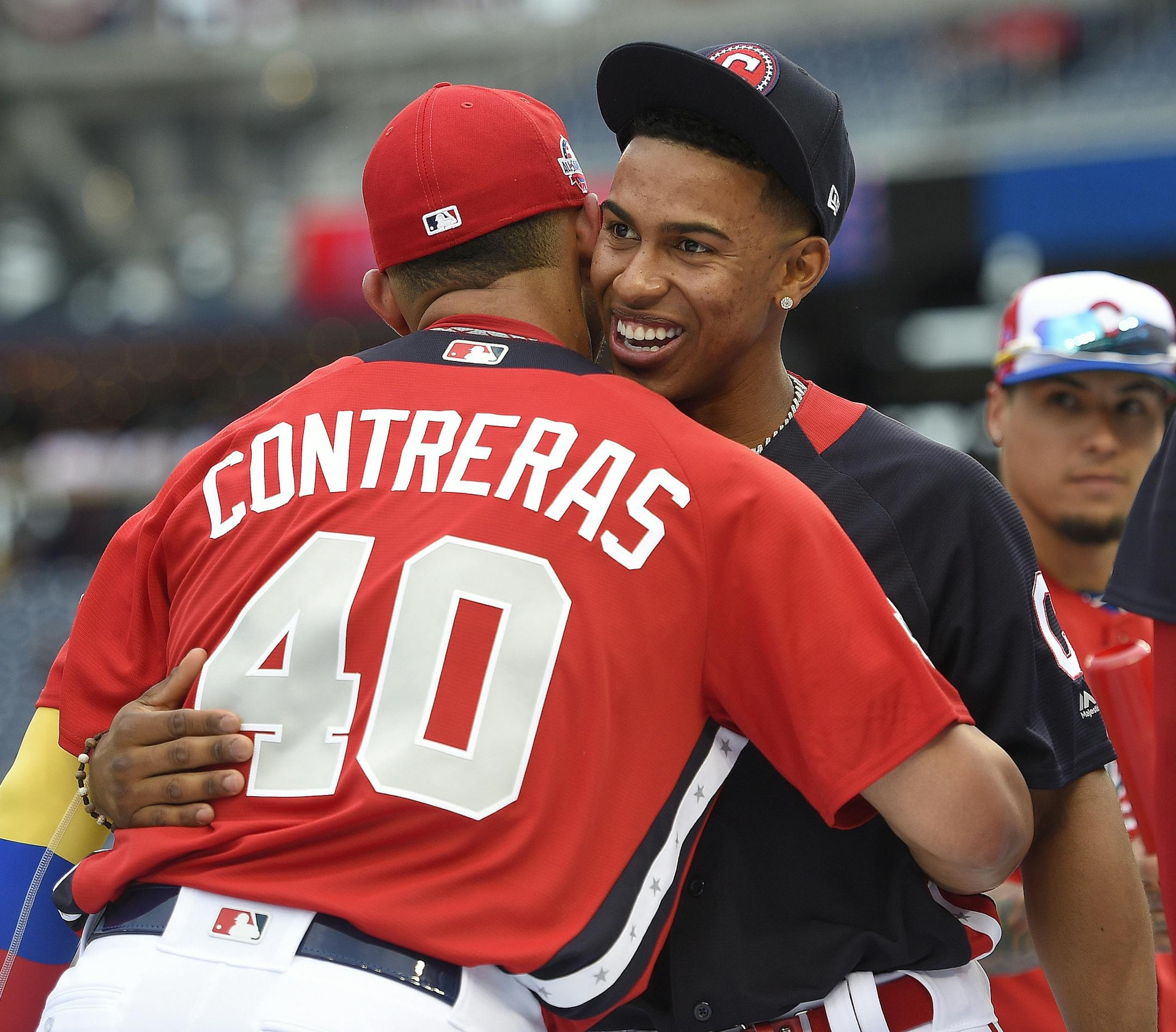 American League, Cleveland Indians Francisco Lindor, right, embraces National League, Chicago Cubs Willson Contreras (40) after batting practice ahead of the All-Star Home Run Derby Baseball event, Monday, July 16, 2018, at Nationals Park, in Washington. The 89th MLB baseball All-Star Game will be played Tuesday. (AP Photo/Nick Wass)