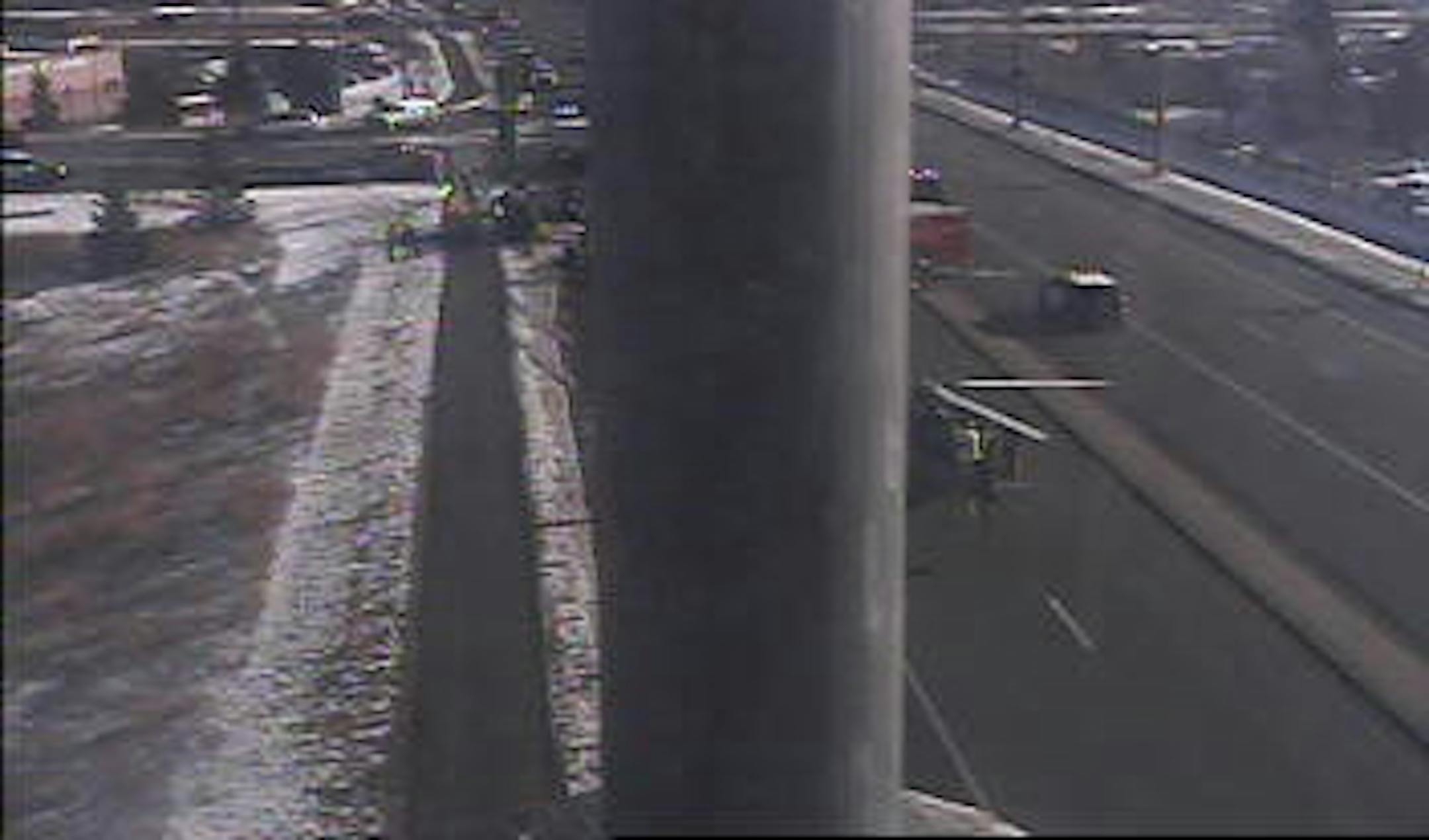 An air ambulance helicopter's blades can be seen to the right of a pillar while emergency workers tp the left of the pillar work at the scene of a rollover crash in Dakota County Monday.