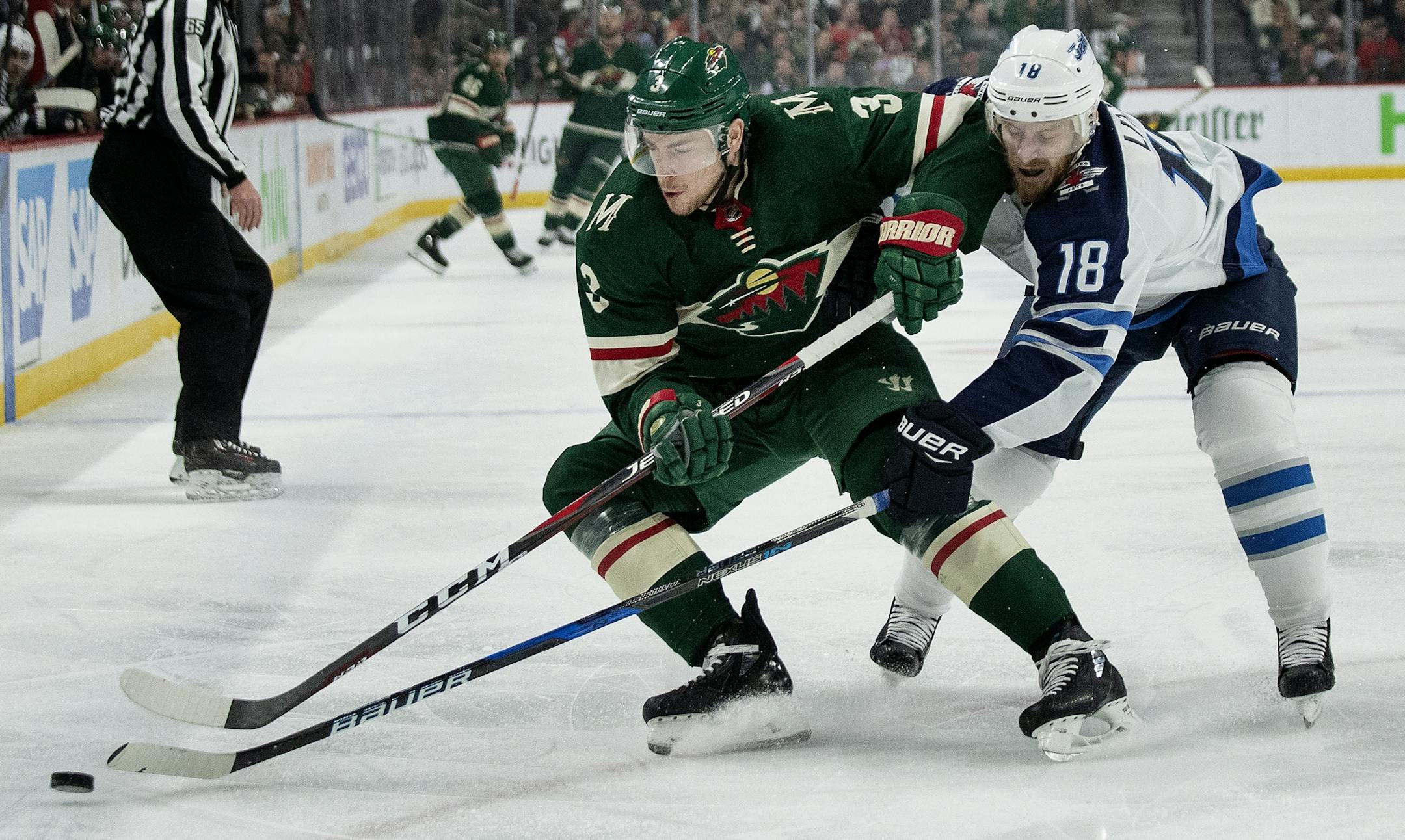 Charlie Coyle (3) and Bryan Little (18) fought for the puck in the first period.