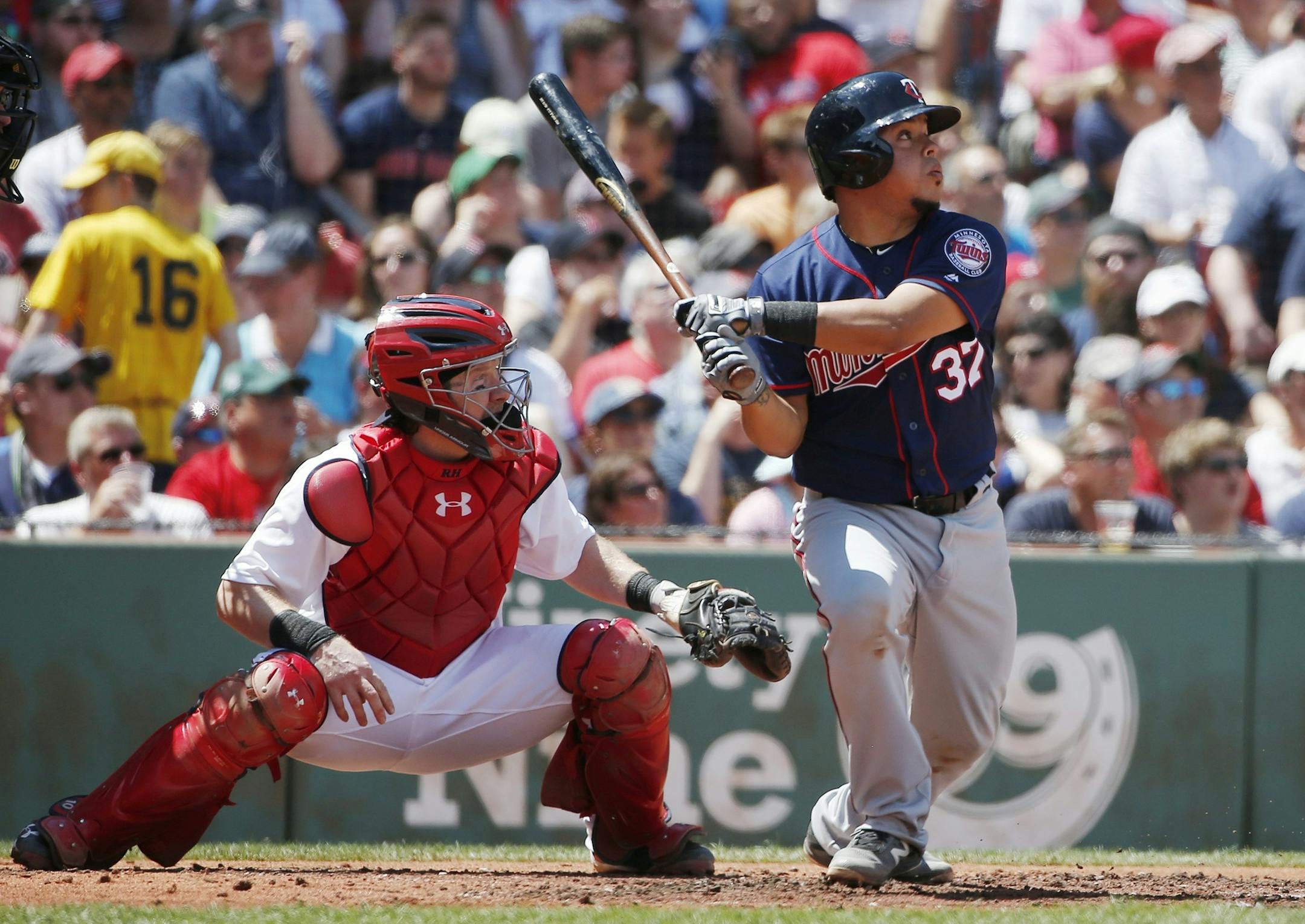 Minnesota Twins' Juan Centeno (37) follows through on a two-run double in front of Boston Red Sox's Ryan Hanigan during the second inning of a baseball game in Boston, Sunday, July 24, 2016. (AP Photo/Michael Dwyer)