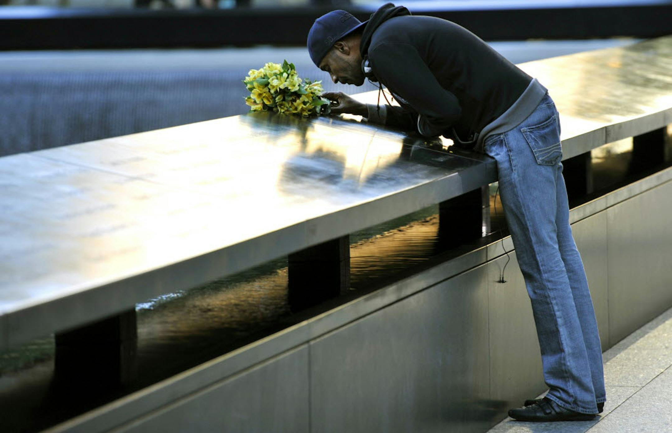 Dennis Swindell kisses the name of his partner, Gary Lee Bright, who died during the 9/ 11 attacks, during the commemoration of the 11th anniversary of the attack at the National Sept. 11 Memorial in New York.