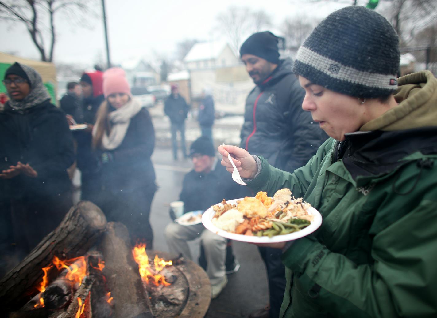 Ray Lockman ate her Thanksgiving dinner by the fire during BlackGiving event in front of the Minneapolis Fourth Precinct. ] (KYNDELL HARKNESS/STAR TRIBUNE) kyndell.harkness@startribune.com BlackGiving event on Plymouth Ave in front of the Minneapolis Fourth Precinct in Minneapolis Min., Thursday November 26, 2015.