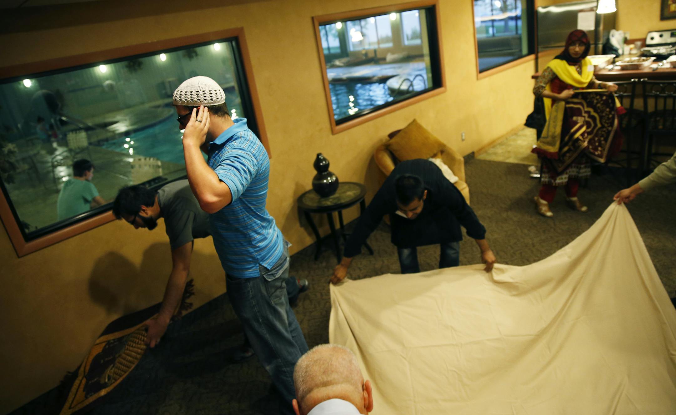 At the community room in an apartment complex in Woodbury, Chris Pleasants, who converted to Islam in 2007, leads the prayers for iftar, the evening meal that breaks the fast during Ramadan .] tsong-taataarii@startribune.com
