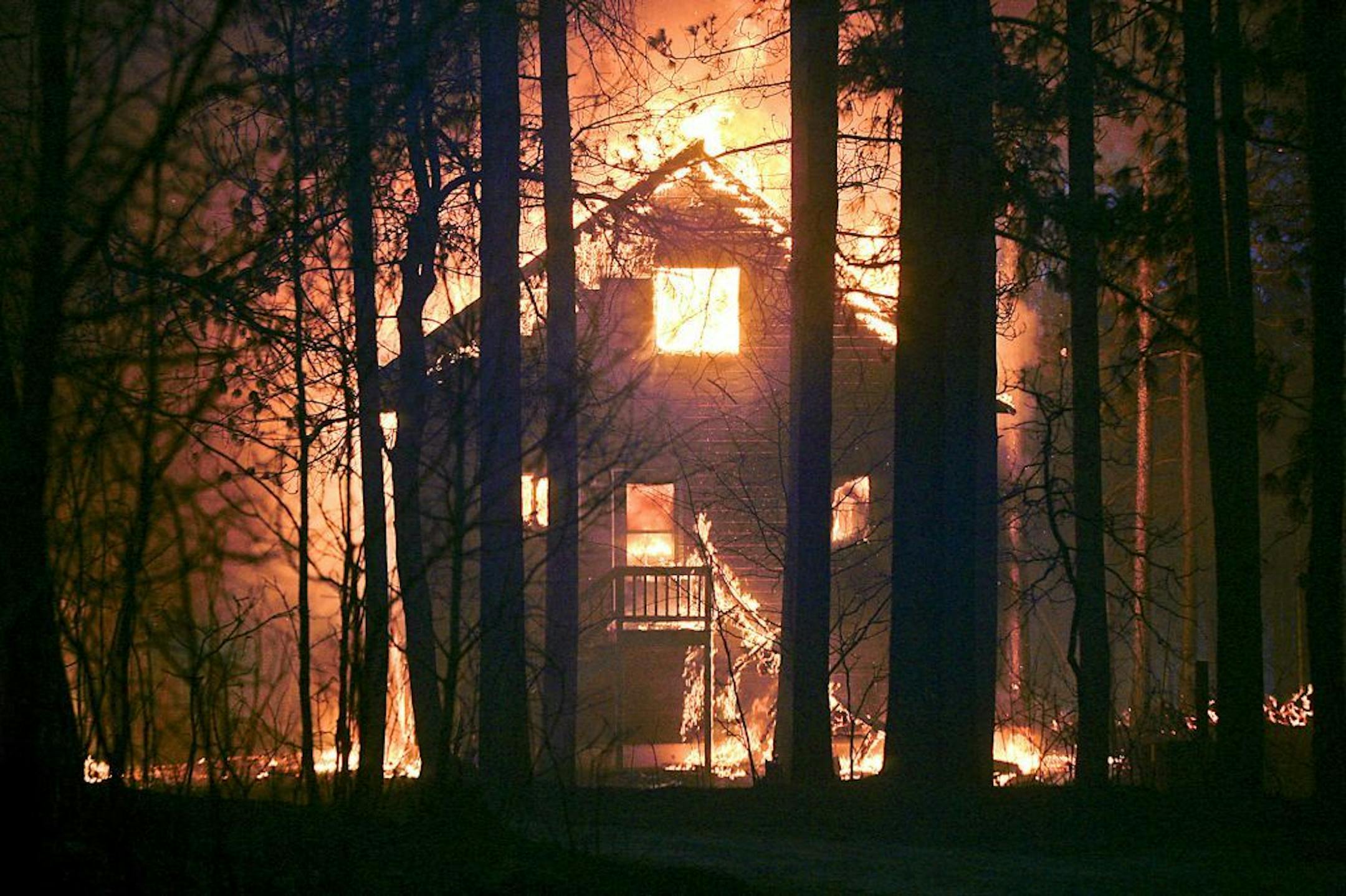 A home is on fire along Sutfin Road east of Comminsky Road in Highland Township, Wis., east of Solon Springs, Wis., late Tuesday, May 14, 2013. Crews from Wisconsin and Minnesota were trying to control a rapidly growing wildfire in northwestern Wisconsin that forced evacuations of the sparsely populated area. Several structures were destroyed in a mostly rural and wooded area east of Solon Springs as the forest fire grew to 9 square miles, the Wisconsin Department of Natural Resources said. No i