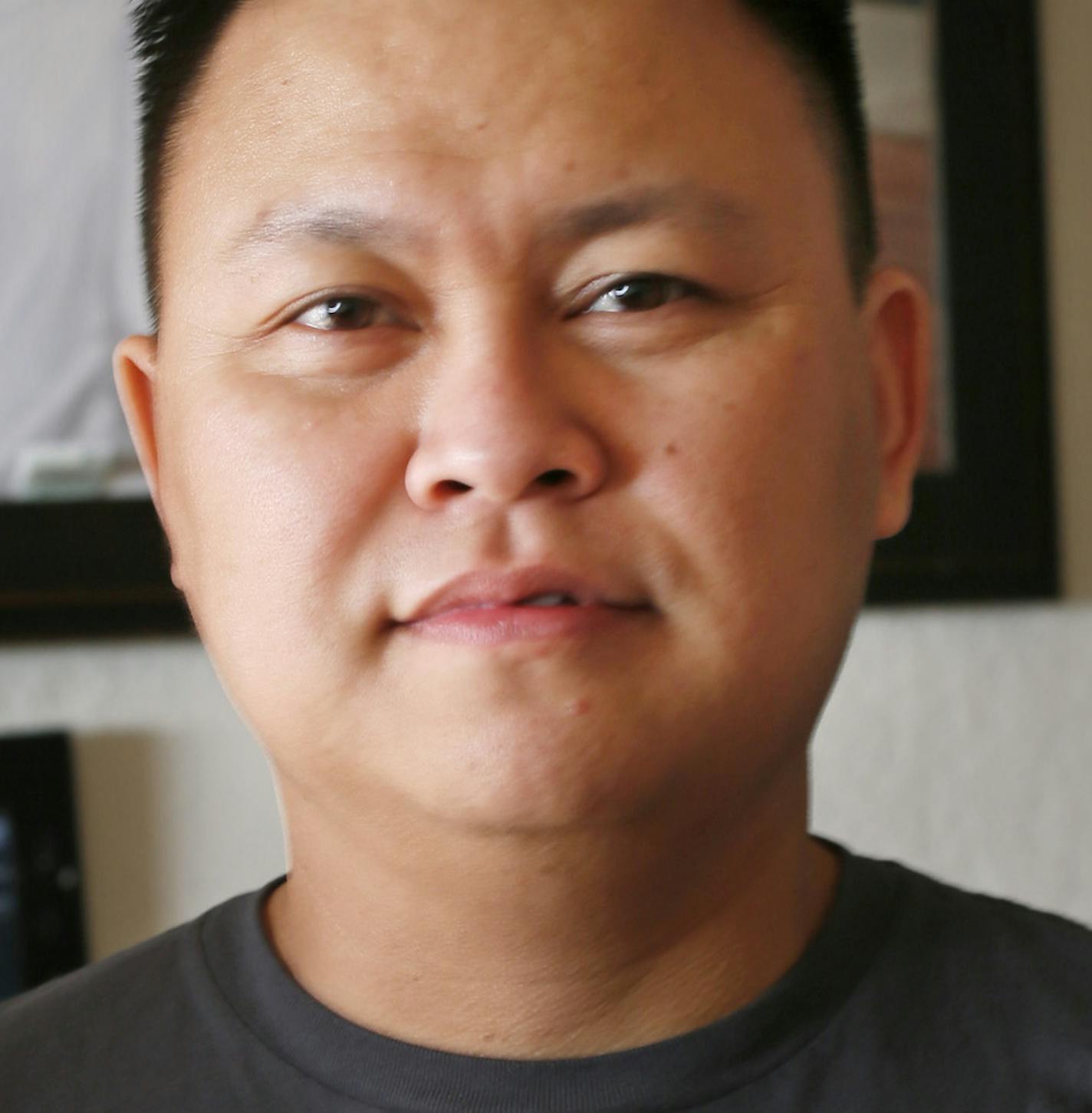 Ximenes Zedekiah held a photograph of his wife parents Ma Khin left (mother) and Aung Myint (father) in front of his wedding portrait with his wife Angela Paw Wednesday 13, 2012 in St. Paul, MN. They are trying to bring Angela's parents here from a refugee camp in Thailand so they can all be reunited as a family. Angela and her husband are both originally from Burma. ] JERRY HOLT &#x201a;&#xc4;&#xa2; jerry.holt@startribune.com