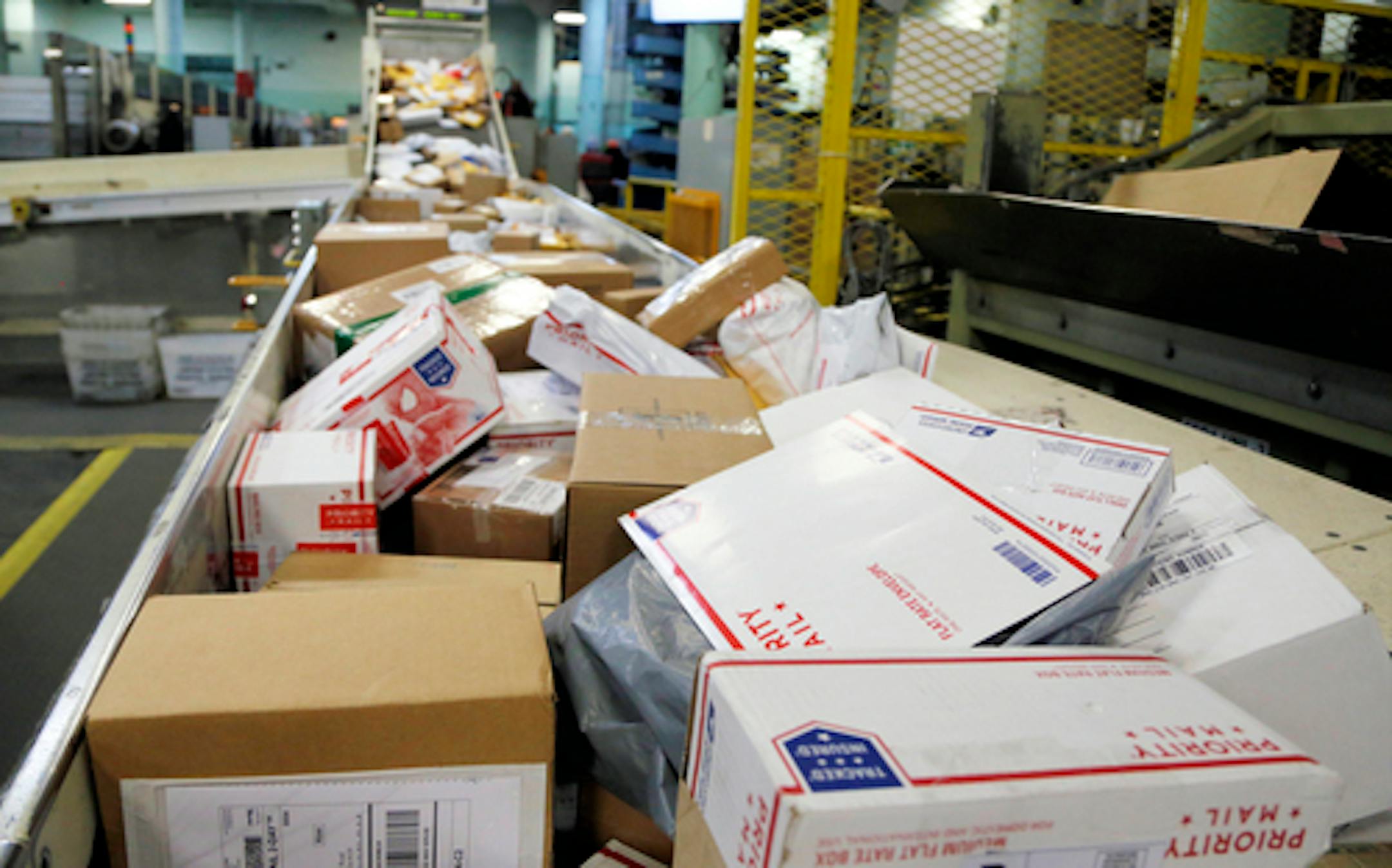 FILE- In this Dec. 14, 2017, file photo, packages travel on a conveyor belt for sorting at the main post office in Omaha, Neb. The city of New York and the state of California sued the U.S. Postal Service Tuesday, Oct. 22, 2019, to stop tens of thousands of cigarette packages from being mailed from foreign countries to U.S. residents, saying the smugglers are engaging in "cigarette tax evasion" while postal workers look the other way. (AP Photo/Nati Harnik, File)