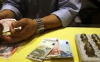 An employee counts British pounds and Euro notes at a currency exchange office in downtown Rome, Tuesday, Oct. 28, 2014. (AP Photo/Gregorio Borgia) OR