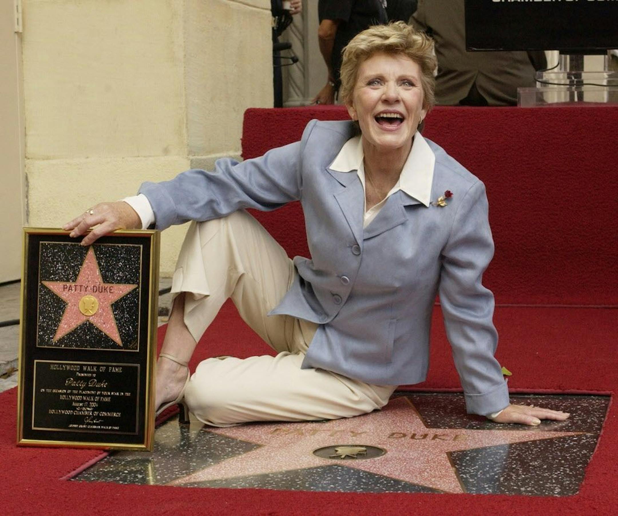 Award-winning actress Patty Duke poses for photographers following an unveiling ceremony, honoring her with the 2,260th star on the Hollywood Walk of Fame in Los Angeles, California August, 17, 2004. Duke won the Oscar for best supporting actress for "The Miracle Worker" at age16, the youngest at the time to be so named. REUTERS/Jim Ruymen
