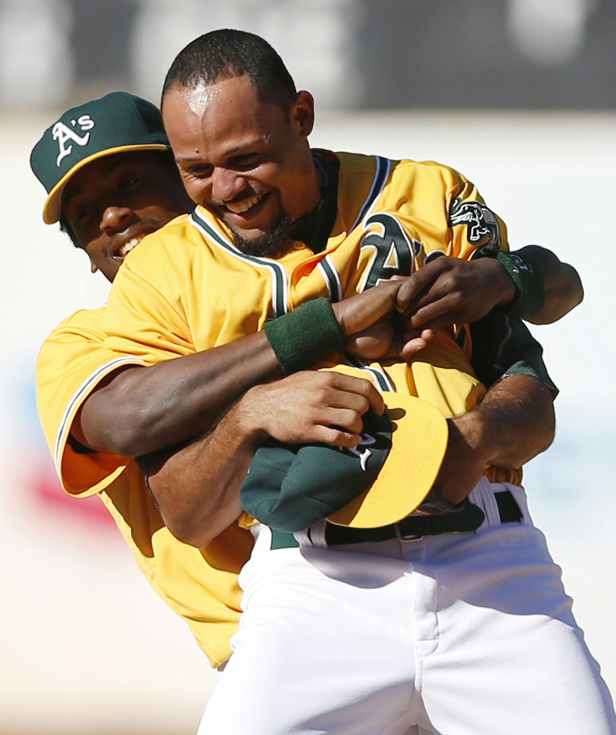 Oakland Athletics' Jemile Weeks, left, picks up teammate Coco Crisp after defeating the Minnesota Twins in a baseball game to become American League West champions, Sunday, Sept. 22, 2013, in Oakland, Calif. (AP Photo/Beck Diefenbach)