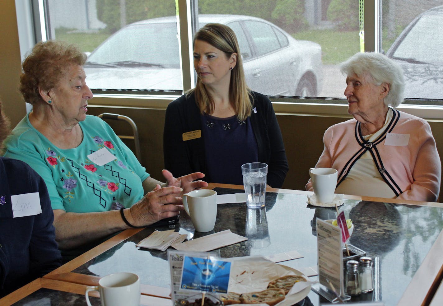 In this photo taken May 20, 2015 at Connections Cafe in Watertown, Wis., Shirley Strysick, right, 90, who suffers from dementia, talks with Stephanie Masche, center, from Heritage Homes assisted living facility, and an unidentified woman during a social and support group for those with the disease and their caregivers. The group called "Memory Cafe" is part of the city's efforts to become dementia friendly. (AP Photo/Carrie Antlfinger) ORG XMIT: RPCA103