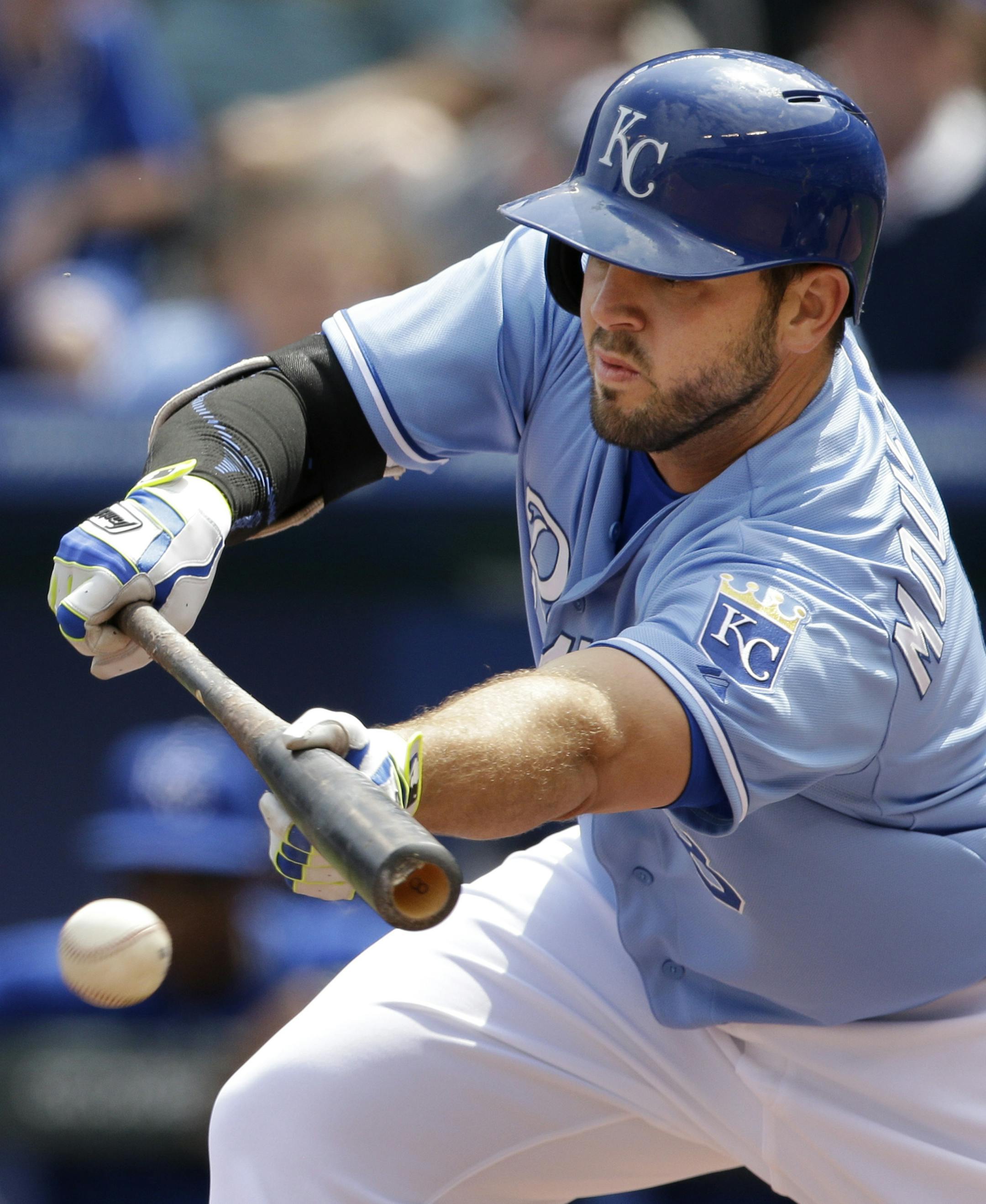 Kansas City Royals' Mike Moustakas puts down a sacrifice bunt during the first inning of a baseball game against the Chicago White Sox at Kauffman Stadium in Kansas City, Mo., Thursday, April 9, 2015. (AP Photo/Orlin Wagner)