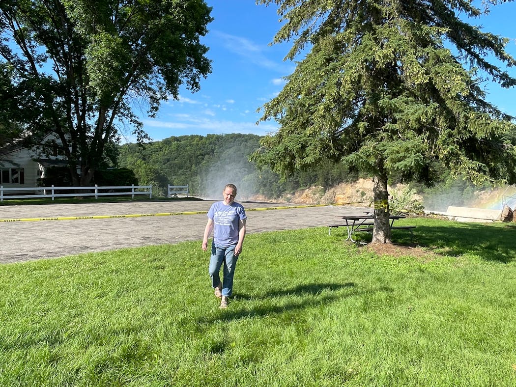 Jenny Barnes walks away from her childhood home that was damaged and then collapsed due to erosion caused by flooding of the nearby Rapidan Dam on Tuesday.