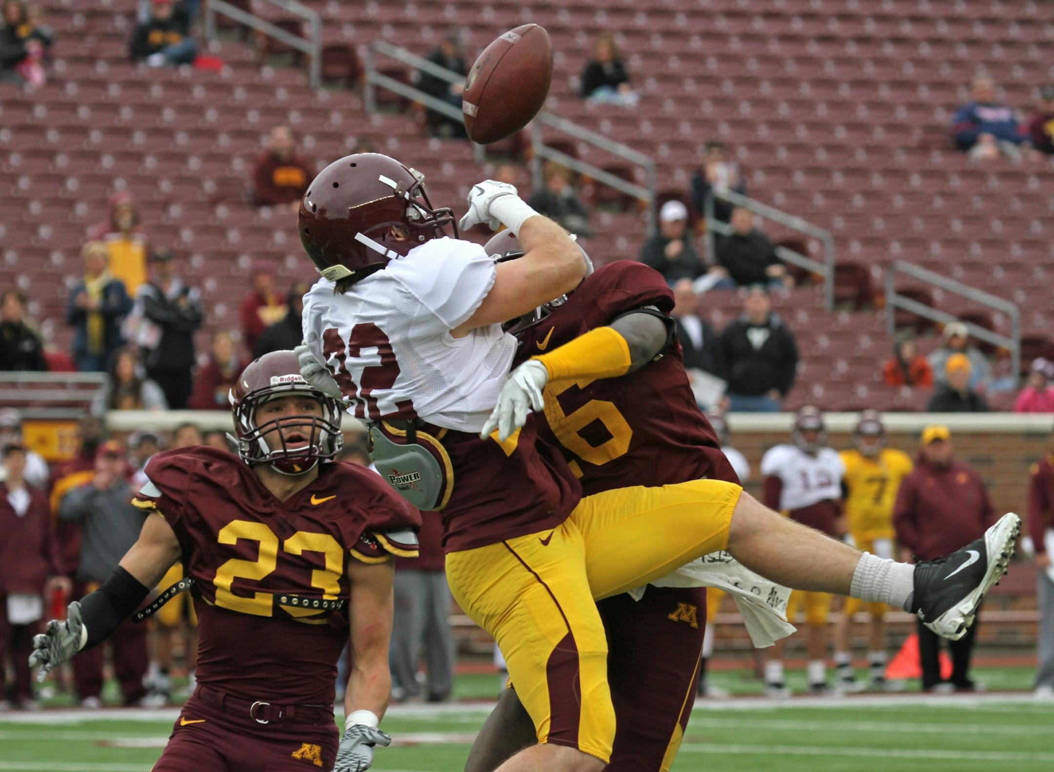 (center) Gold Roster Wide Receiver A.J. Barker couldn't pull in a pass as he was defended by the Maroon Roster (left) Grayson Levine and (right) Steven Montgomery as the Gophers wrapped up spring football practice with the spring game at TCF Bank Stadium on 4/21/12.