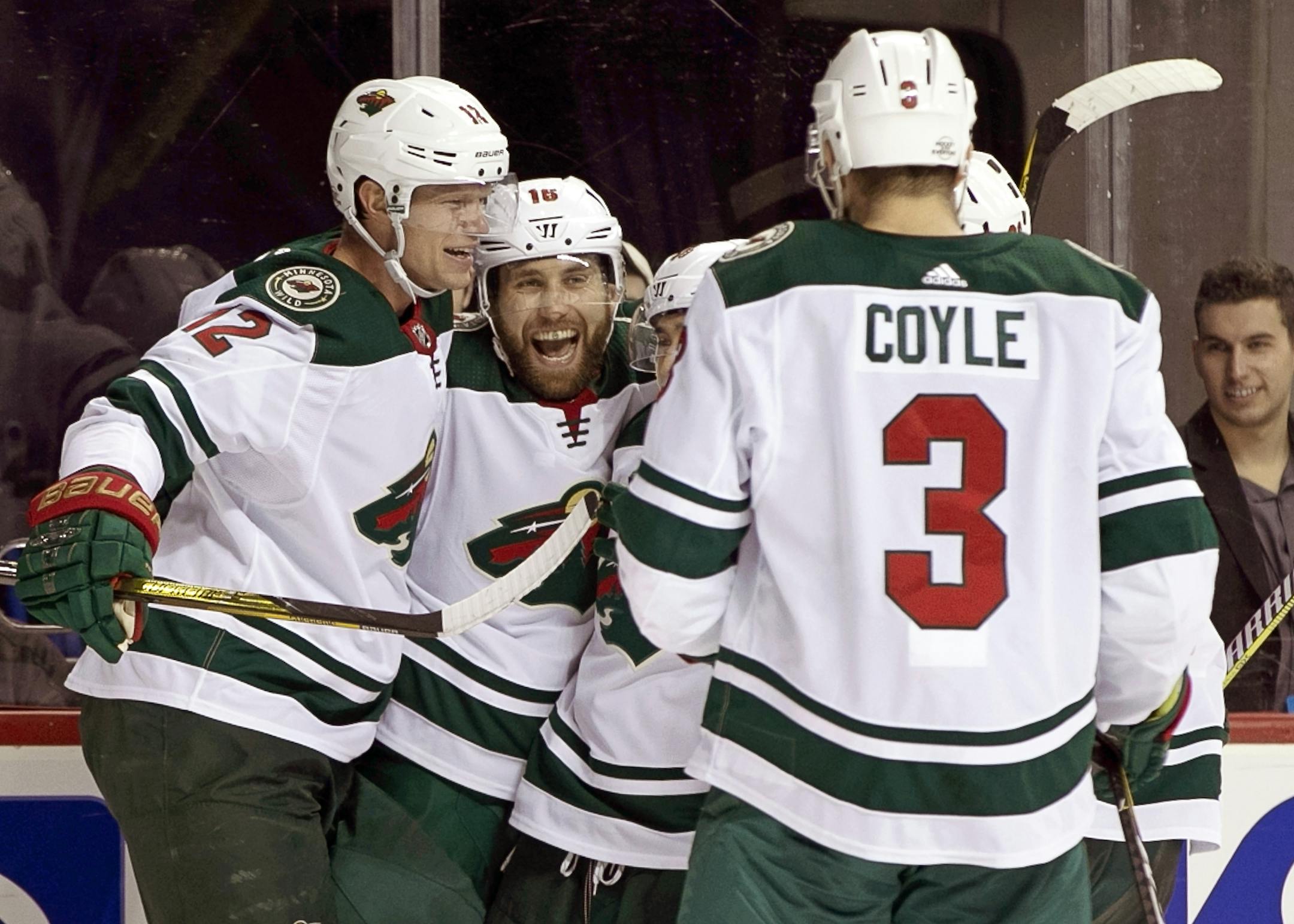 Minnesota Wild center Eric Staal (12) celebrates wtih Wild left wing Jason Zucker (16) who scored a goal on New York Islanders goaltender Jaroslav Halak during the third period of an NHL hockey game in New York, Monday, Feb. 19, 2018. Zucker scored two goals to help the Wild defeat the Islanders 5-3. Wild center Charlie Coyle (3) watches the celebration. (AP Photo/Kathy Willens)
