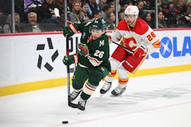 Wild center Connor Dewar controlled the puck with Flames center Elias Lindholm in pursuit during the first period Thursday.