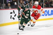 Wild center Connor Dewar controlled the puck with Flames center Elias Lindholm in pursuit during the first period Thursday.