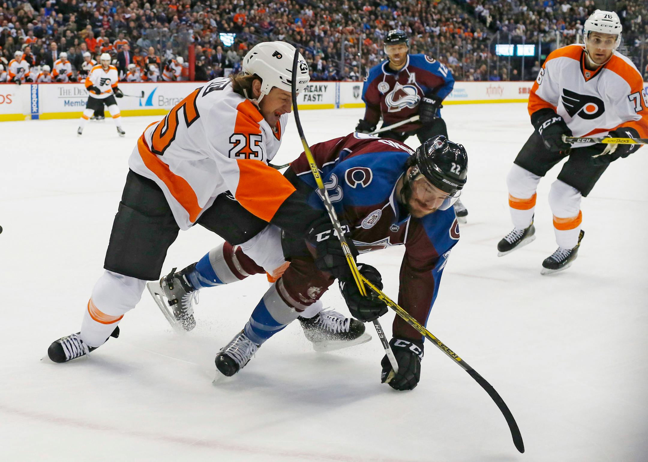 Flyers center Ryan White knocked over Avalanche defenseman Zach Redmond as they pursued the puck in the second period Thursday in Denver.