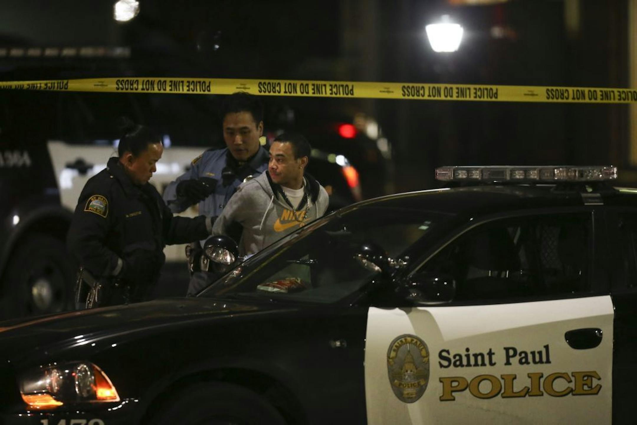 St. Paul Police officers searched a man who was handcuffed before putting him the back of a squad car in front of the Midway Motel late Tuesday night.