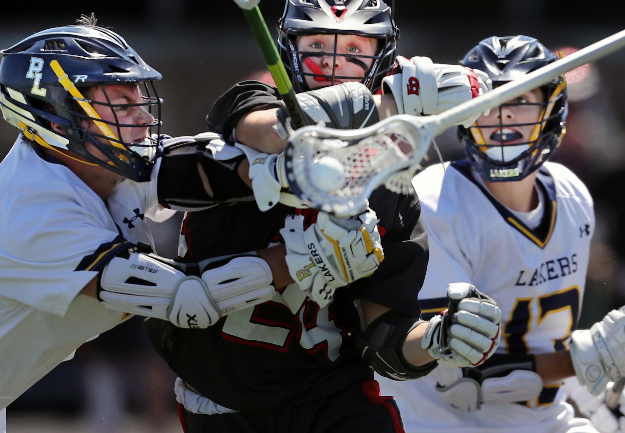 Jack Dessler(7) far left, and Ryan Larson(13), far right muscle in on Thomas Hartle(24) center. [At Chanhassen H.S. in a semifinal lacrosse game between Prior Lake and Eden Prairie. Richard Tsong-Taatarii/rtsong-taatarii@startribune.com