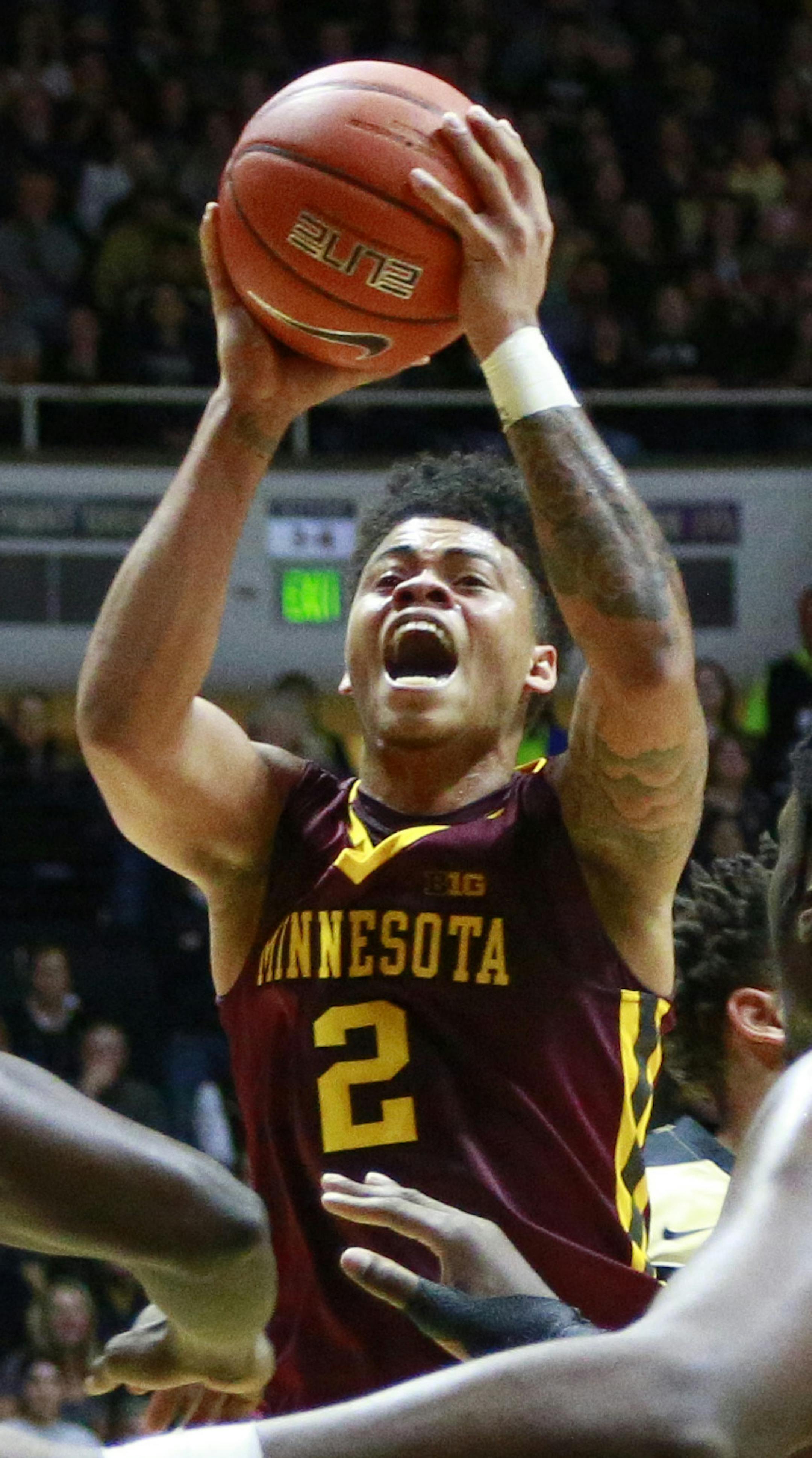 Minnesota guard Nate Mason (2) shoots in front of Minnesota center Bakary Konate (21) and Purdue forward Caleb Swanigan in the first half of an NCAA college basketball game, Sunday, Jan. 1, 2017, in West Lafayette, Ind. (AP Photo/R Brent Smith)
