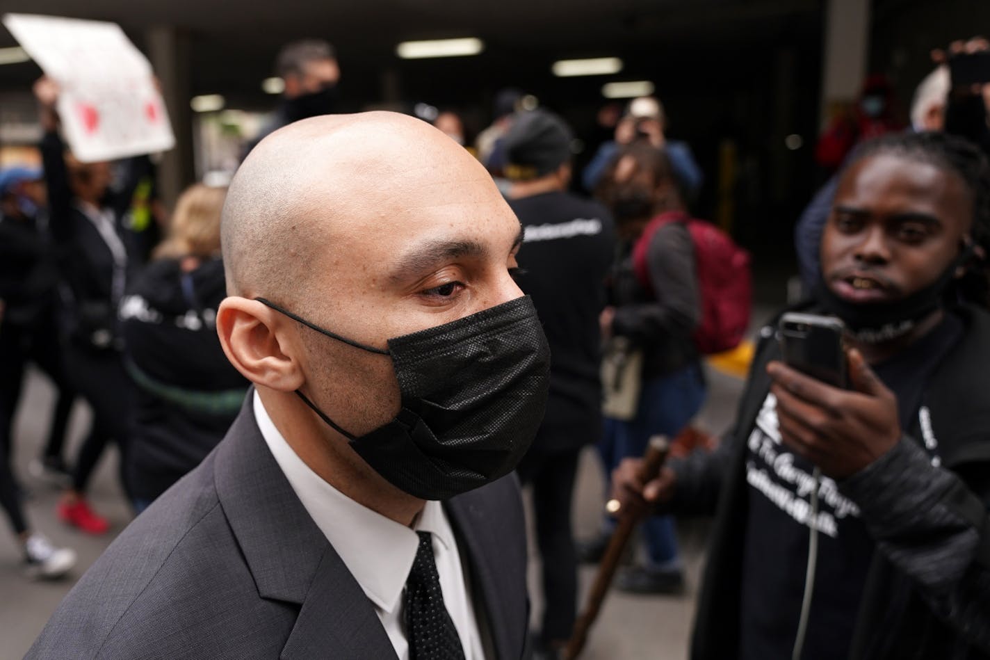 Former Minneapolis police officer J. Alexander Kueng was screamed at by protesters as he walked to a car with fellow former officer Thomas Lane from Friday's hearing.