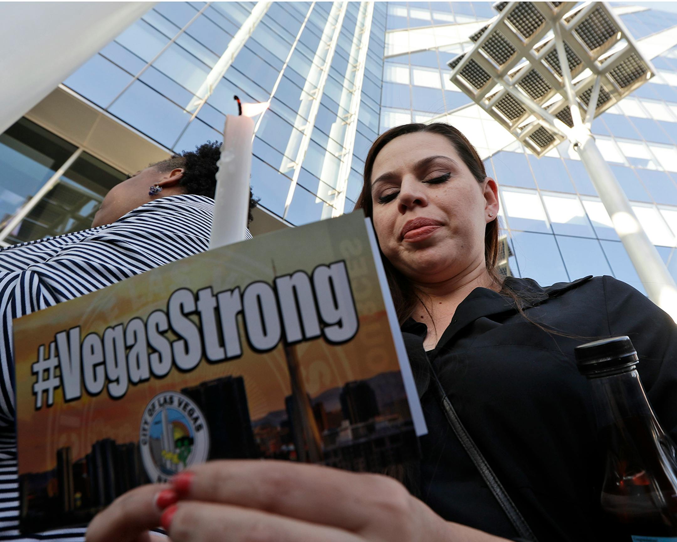 Kristin Alexander holds a candle during a vigil at City Hall in Las Vegas, Monday, Oct. 2, 2017. The vigil was held in honor of the over 50 people killed and hundreds injured in a mass shooting at an outdoor music concert late Sunday. (AP Photo/Gregory Bull)