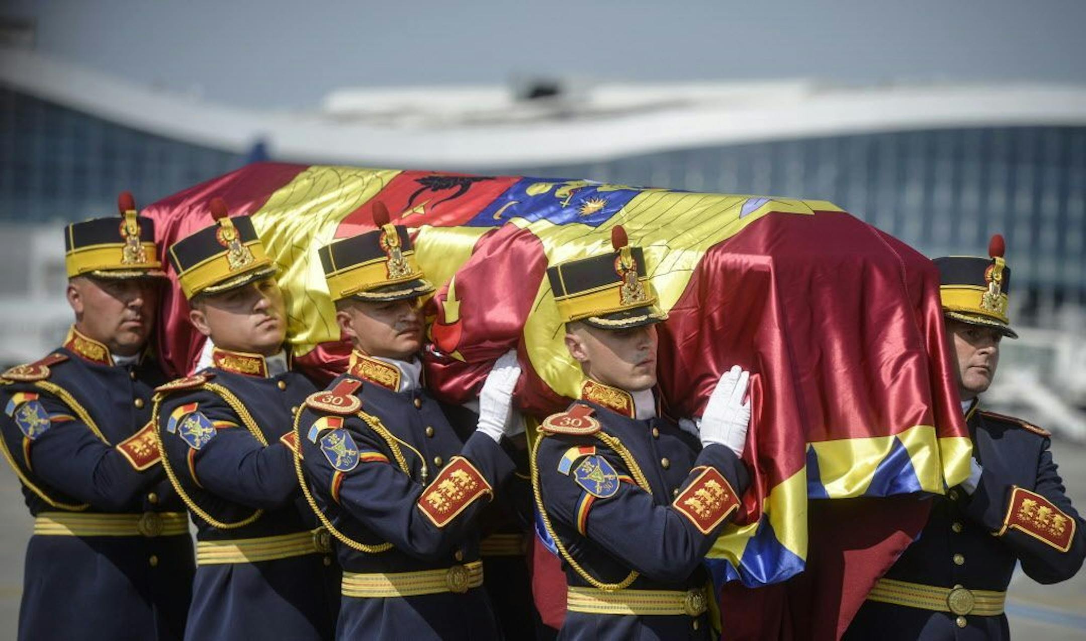 An honor guard soldiers carry the flag-draped coffin of Anne of Romania, wife of Romania's last monarch King Michael, before a religious service, in Otopeni, Romania, Tuesday, Aug. 9, 2016. The body of Anne of Romania, the wife of the country's ex-king, arrived in Bucharest Tuesday for the biggest royal funeral in almost 80 years.