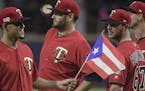 CORRECTS RIVAL TEAM TO CLEVELAND INDIANS - Minnesota Twins starting pitcher Jose Berrios enters the field holding a Puerto Rican flag before game one 