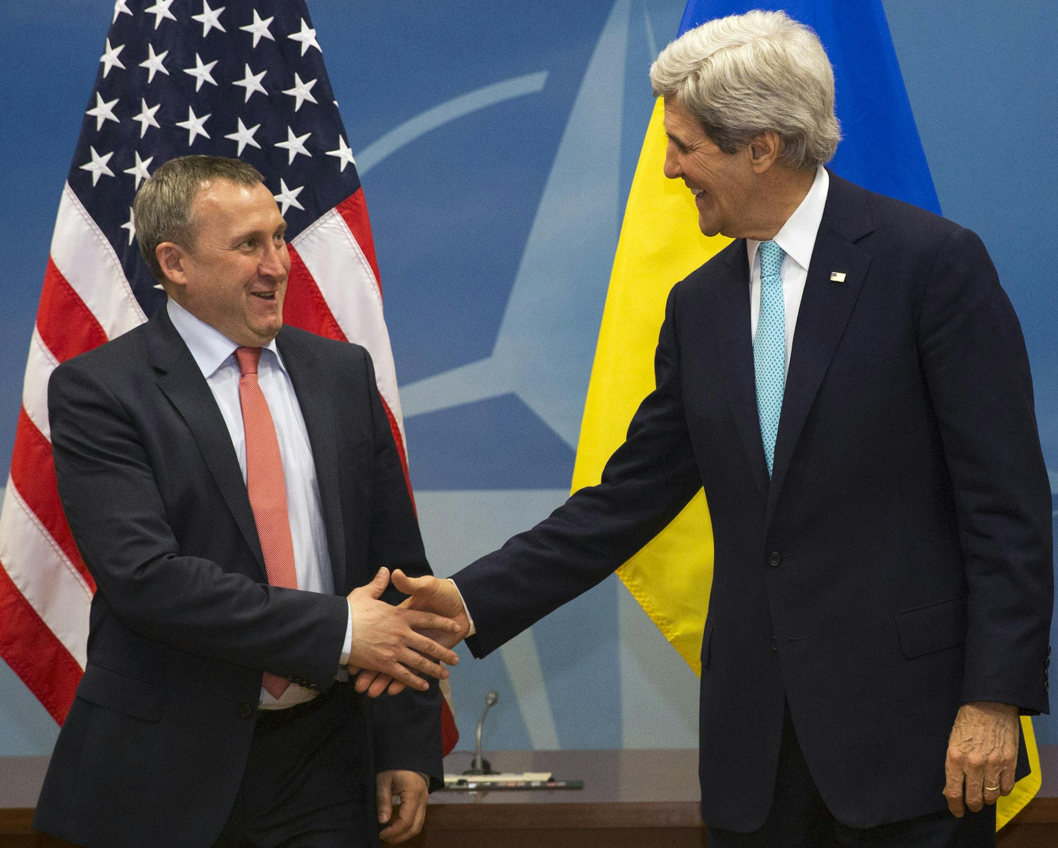 U.S. Secretary of State John Kerry, right, shakes hands with Ukrainian Foreign Minister Andriy Deshchytsia before their meeting at NATO Headquarters in Brussels, Tuesday April 1, 2014. (AP Photo/Jacquelyn Martin, Pool)