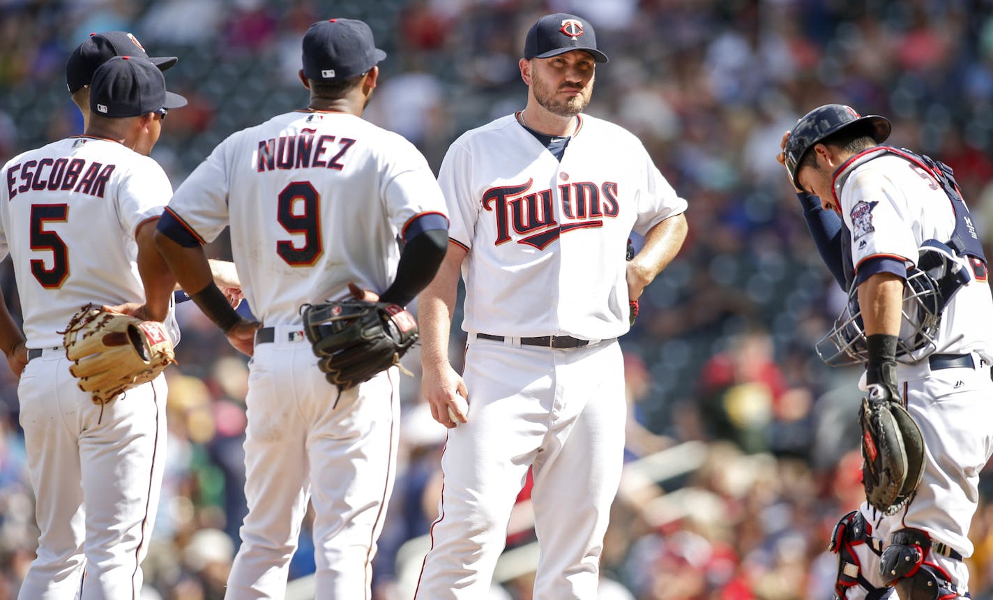 Minnesota Twins relief pitcher Kevin Jepsen, second from the right, awaits the manager to relinquish the ball against the Tampa Bay Rays in the ninth inning of a baseball game, Sunday, June 5, 2016, in Minneapolis. With him are Eduardo Escobar, Eduardo Nunez, and Kurt Suzuki, right. The Rays won 7-5. (AP Photo/Bruce Kluckhohn)