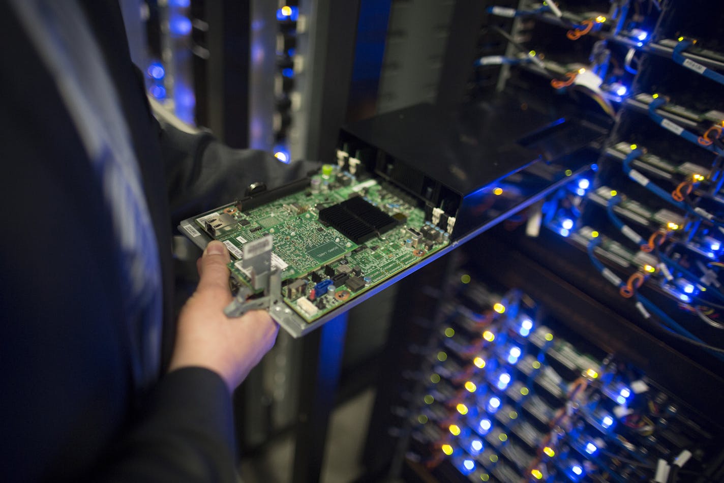 An employee removes a printed circuit board (CPU) from a server rack at Facebook Inc.'s new data storage center near the Arctic Circle in Lulea, Sweden.