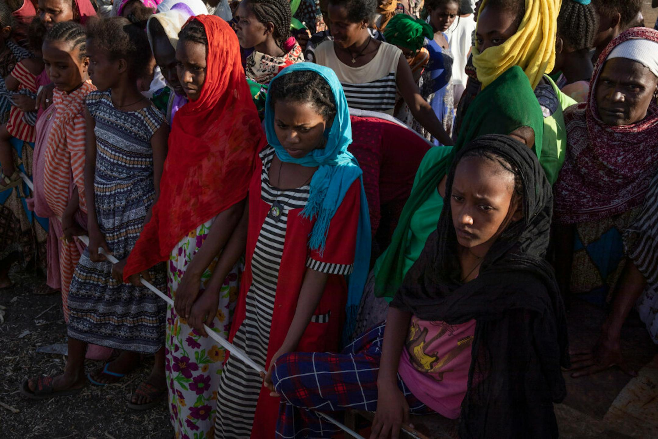 Tigray women who fled the conflict in the Ethiopia's Tigray region, wait to receive aid at Village 8, the transit centre near the Lugdi border crossing, eastern Sudan, Sunday, Nov. 22, 2020. Ethiopia's military is warning civilians in the besieged Tigray regional capital that there will be "no mercy" if they don't "save themselves" before a final offensive to flush out defiant regional leaders, a threat that Human Rights Watch on Sunday said could violate international law.