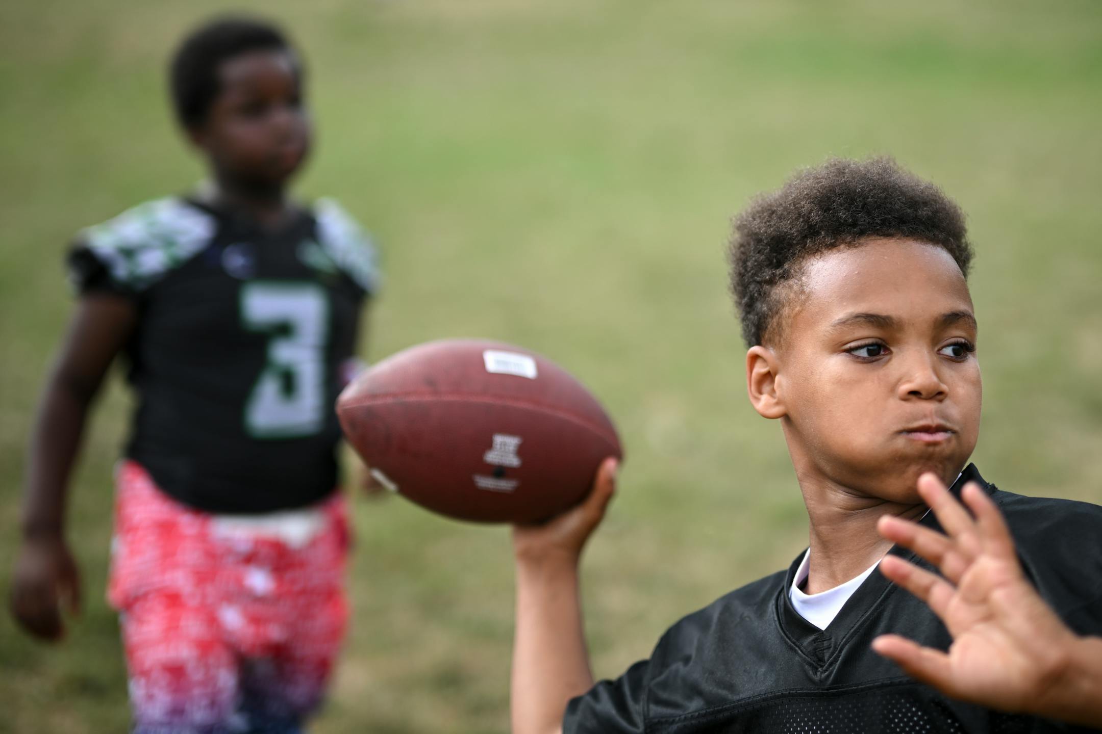 Chance Eggleston, 10, throws a football before practice.