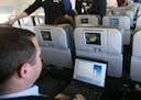 FILE - In this file photo made Dec. 5, 2007, a person demonstrates the capabilities of a laptop during a media preview flight aboard "BetaBlue," an Ai