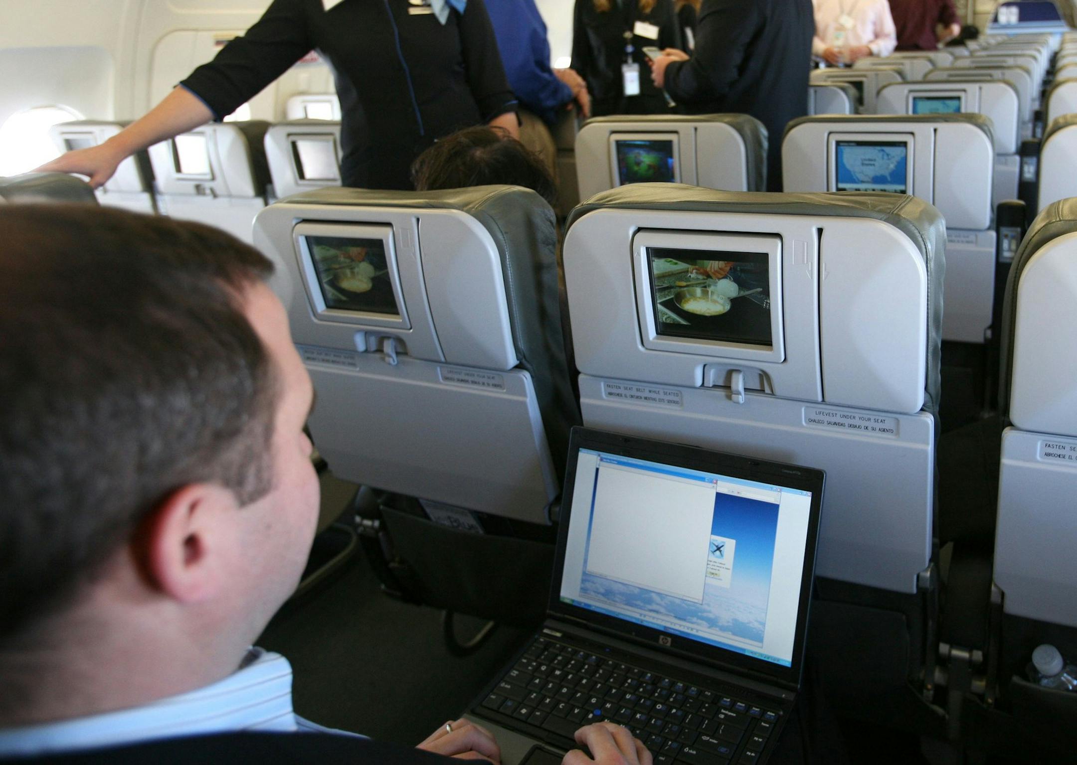 FILE - In this file photo made Dec. 5, 2007, a person demonstrates the capabilities of a laptop during a media preview flight aboard "BetaBlue," an Airbus A320 aircraft equipped with an onboard wireless network in New York. Airline technology consultant Michael Planey thinks Wi-Fi will be free as early as mid-2011. (AP Photo/Mark Lennihan, File)
