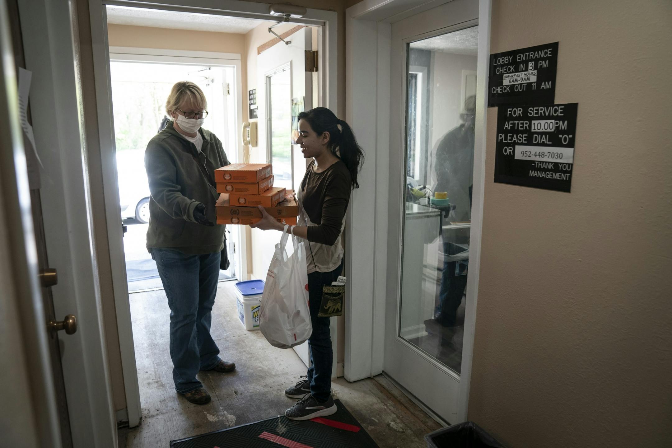Chaska Super 8 general manager Sana Cheema (right) collected donated food from Chick-fil-A and Little Caesars from Martha Brannon of His House Foundation. Brannon brought the donated food to the hotel that is sheltering homeless people in Chaska, Minn., on Friday, May 15, 2020.
