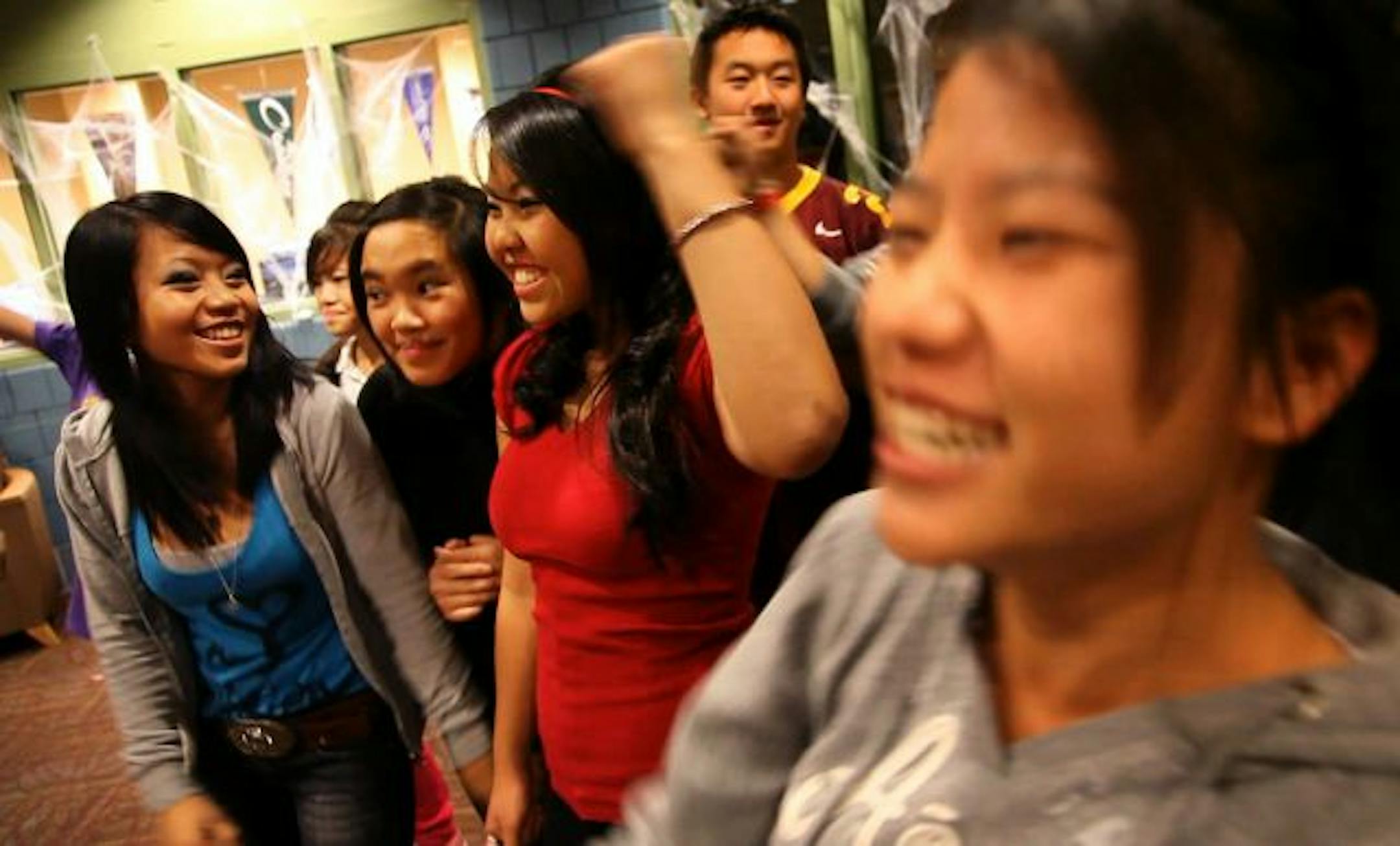 A group of students from the Neighborhood House — including Der, left, and Kabao, in red — pumped their fists while chanting, "Teacher, leave those kids alone," during a practice for "The Wall Live" in St. Paul.